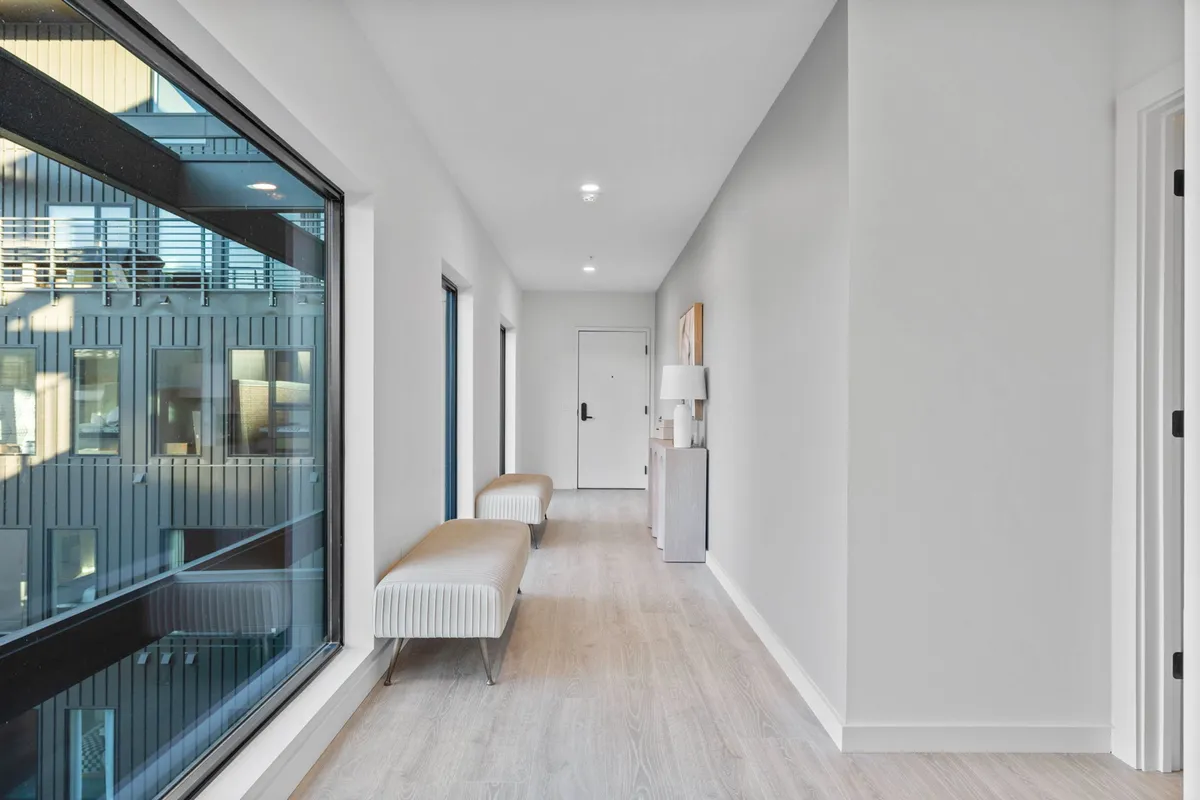 A stylish entryway with large windows, minimalist benches, and eye-catching artwork. The design feels both welcoming and modern, setting the stage for the home's atmosphere right as you walk in.